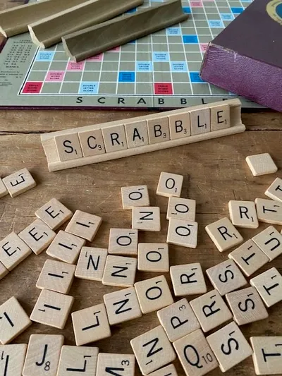 Lettres de Scrabble sur une table en bois : moments de jeu et lien social avec une personne âgée